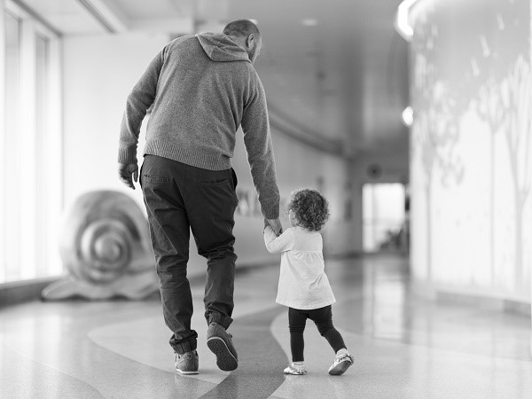 father and daughter walking down hospital hallway